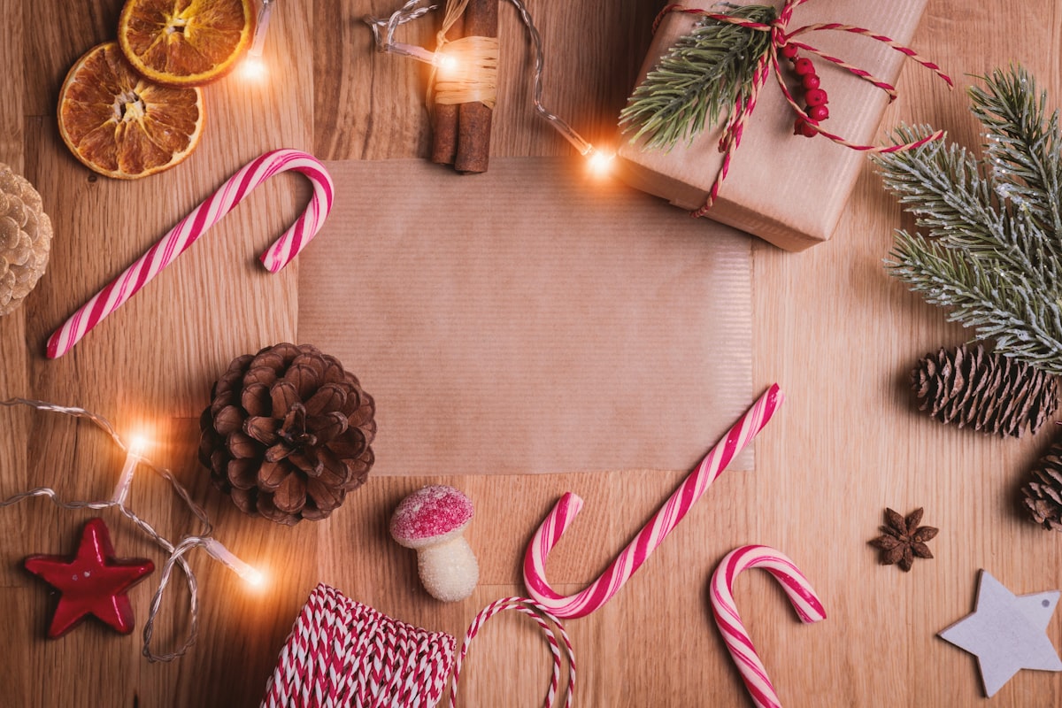Candy canes, pine sprigs, and holiday trimmings on a wooden table